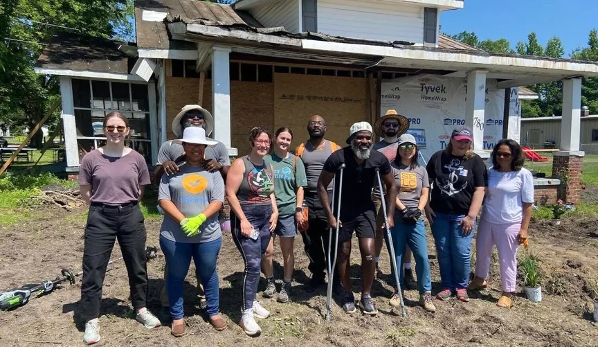 a group of people standing in front of a building under construction